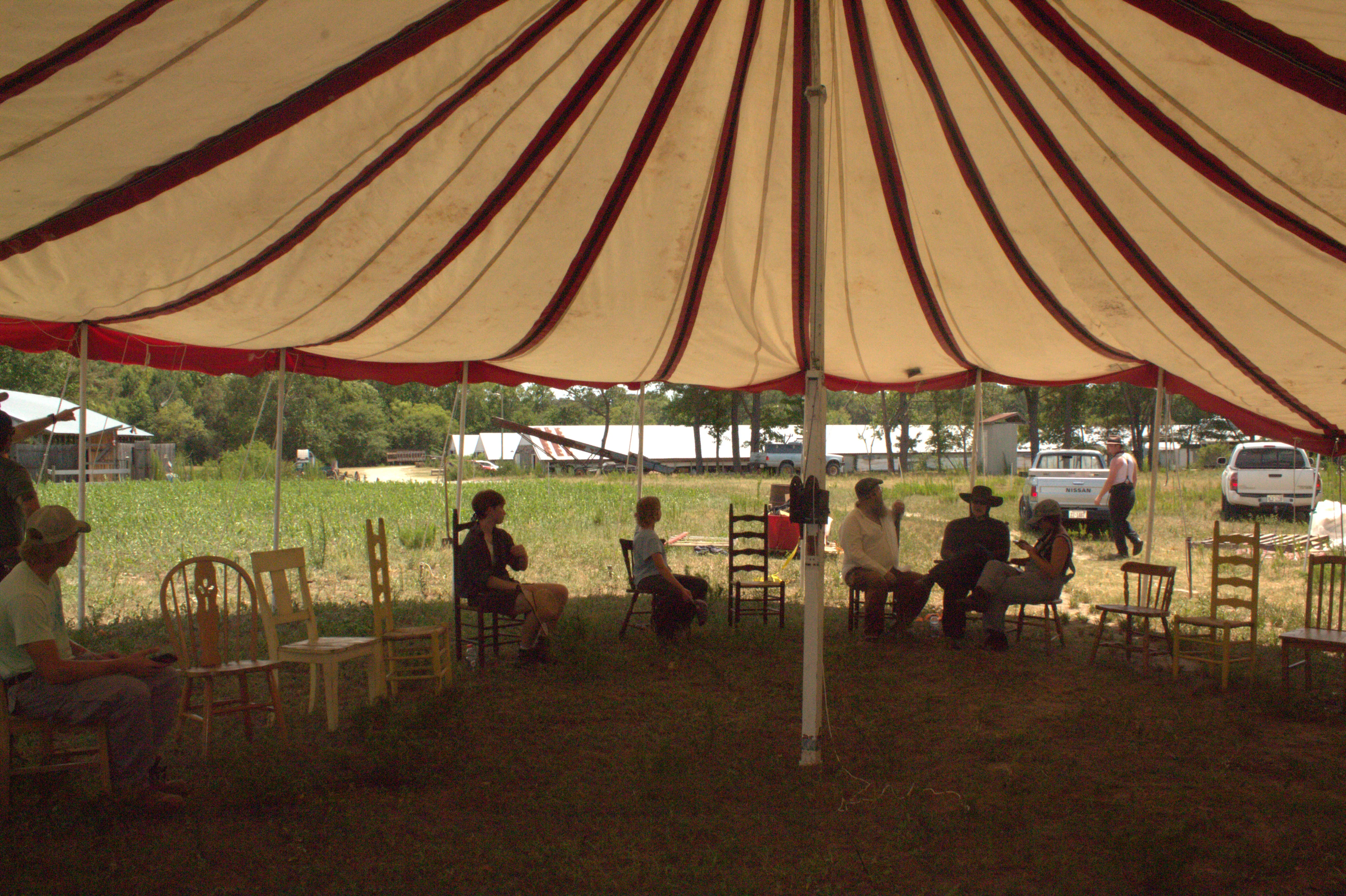 Two performers beside the tent sidewall